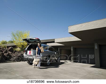 Stock Photograph - Woman with groceries leaving car. Fotosearch