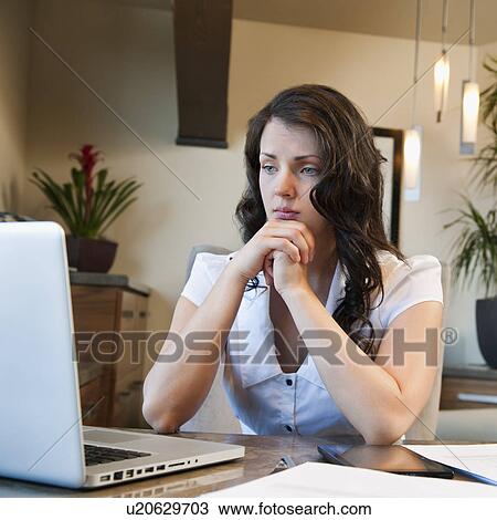 Stock Image - Woman working from home. Fotosearch