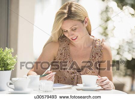 Woman writing journal at outdoor cafe table View Large Photo Image Stock Image - Woman writing journal at outdoor cafe table. Fotosearch