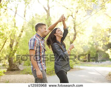 Stock Photo - Young couple dancing togetherness in park. Fotosearch
