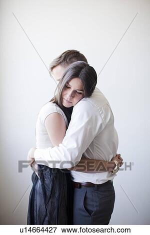 Young couple embracing, studio shot View Large Photo Image Stock Photo - Young couple embracing, studio shot. Fotosearch
