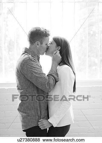 Stock Photo - Young couple kissing. Fotosearch