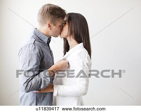 Young couple kissing, studio shot View Large Photo Image Stock Photo - Young couple kissing, studio shot. Fotosearch