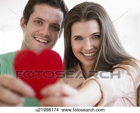 Picture - Young couple showing red heart. Fotosearch