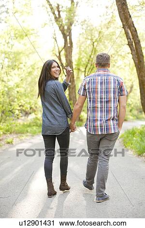 Young couple walking togetherness View Large Photo Image Stock Image - Young couple walking togetherness. Fotosearch