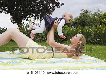 Young mother playing with daughter outdoor View Large Photo Image Stock Image - Young mother playing with daughter outdoor. Fotosearch