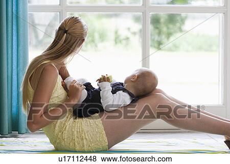 Young mother with daughter looking through window View Large Photo Image Stock Photo - Young mother with daughter looking through window. Fotosearch