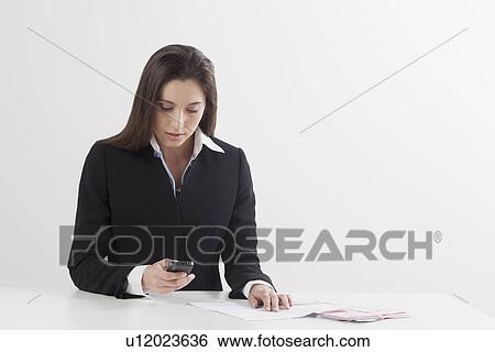Stock Photograph - Young woman paying bill with her mobile phone. Fotosearch
