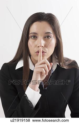 Young woman with finger on her lips, studio shot View Large Photo Image Stock Photo - Young woman with finger on her lips, studio shot. Fotosearch