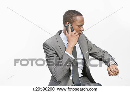 African American businessman checking time while on a call View Large Photo Image Stock Image - African American businessman checking time while on a call. Fotosearch