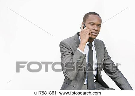 African American businessman conversing on cell phone over white background View Large Photo Image Stock Image - African American businessman conversing on cell phone over white background. Fotosearch