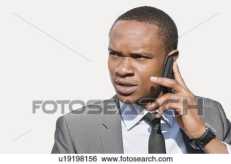African American businessman looking away while talking on cell phone View Large Photo Image Stock Photograph - African American businessman looking away while talking on cell phone. Fotosearch