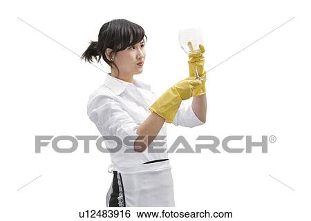 Asian house cleaner looking at glass over white background View Large Photo Image Stock Photograph - Asian house cleaner looking at glass over white background. Fotosearch