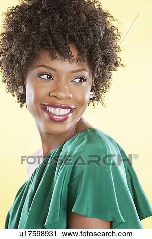 Attractive African American woman in an off shoulder dress looking away over colored background View Large Photo Image Stock Image - Attractive African American woman in an off shoulder dress looking away over colored background. Fotosearch