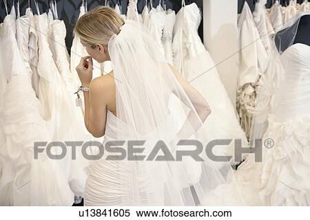 Back view of a young woman in wedding dress looking at bridal gowns on display in boutique View Large Photo Image Stock Photography - Back view of a young woman in wedding dress looking at bridal gowns on display in boutique. Fotosearch