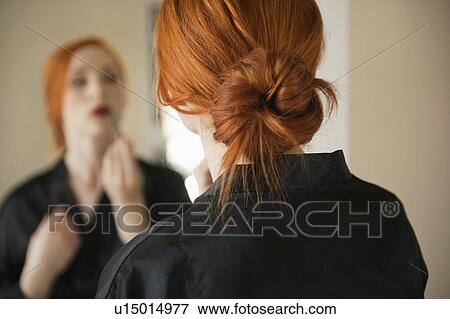 Stock Photo - Back view of young woman applying makeup. Fotosearch