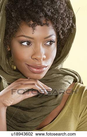 Stock Image - Beautiful African American woman looking away over colored background. Fotosearch