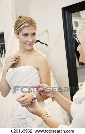 Beautiful young bride with mother looking at price tag of bracelet in bridal store View Large Photo Image Stock Image - Beautiful young bride with mother looking at price tag of bracelet in bridal store. Fotosearch