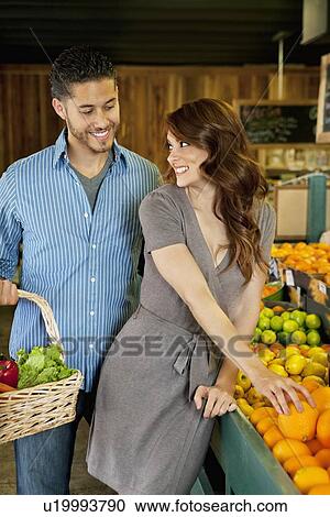 Beautiful young couple shopping together in market View Large Photo Image Stock Image - Beautiful young couple shopping together in market. Fotosearch