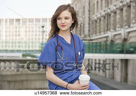 Stock Photo - Beautiful young female doctor on a work break. Fotosearch