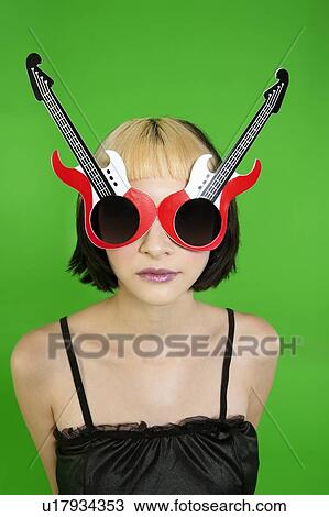 Beautiful young model with guitar shaped sunglasses over green background View Large Photo Image Stock Image - Beautiful young model with guitar shaped sunglasses over green background. Fotosearch