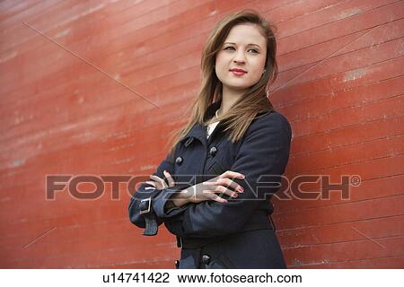 Stock Image - Beautiful young professional with arms crossed looking away. Fotosearch