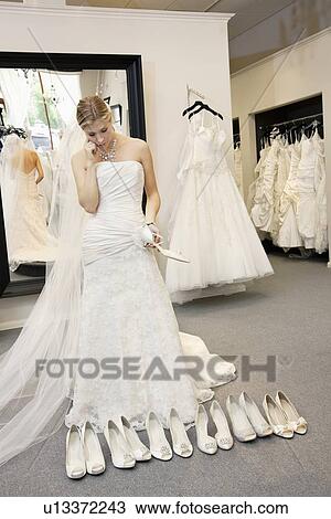 Beautiful young woman confused while selecting footwear in bridal boutique View Large Photo Image Stock Image - Beautiful young woman confused while selecting footwear in bridal boutique. Fotosearch
