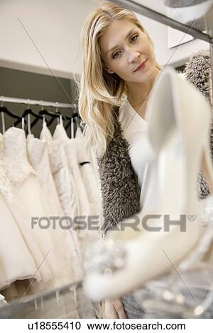 Beautiful young woman looking at footwear in bridal boutique View Large Photo Image Stock Image - Beautiful young woman looking at footwear in bridal boutique. Fotosearch