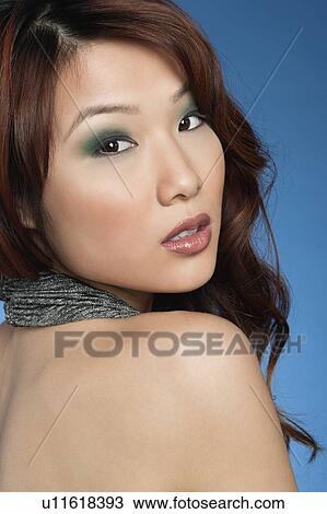 Beautiful young woman with eye shadow looking back over colored background View Large Photo Image Stock Image - Beautiful young woman with eye shadow looking back over colored background. Fotosearch