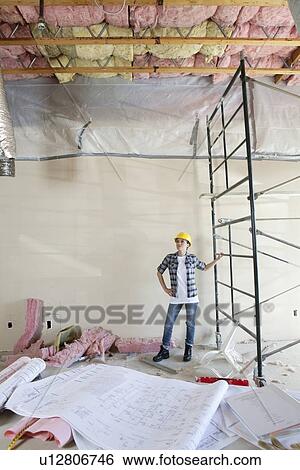 Blueprints on table in front of mid adult architect looking at ceiling View Large Photo Image Stock Photograph - Blueprints on table in front of mid adult architect looking at ceiling. Fotosearch