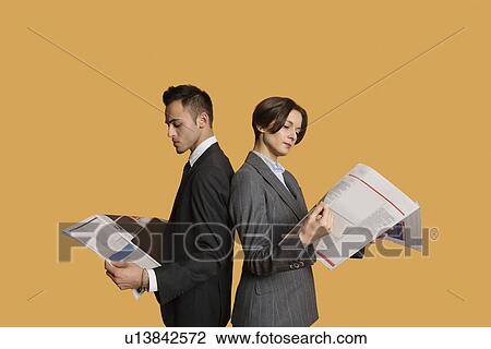 Business partners standing back to back while reading newspaper View Large Photo Image Stock Image - Business partners standing back to back while reading newspaper. Fotosearch