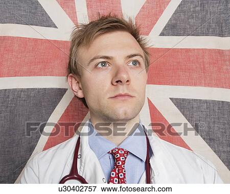 Caucasian doctor looking away with British Flag in background View Large Photo Image Stock Photo - Caucasian doctor looking away with British Flag in background. Fotosearch