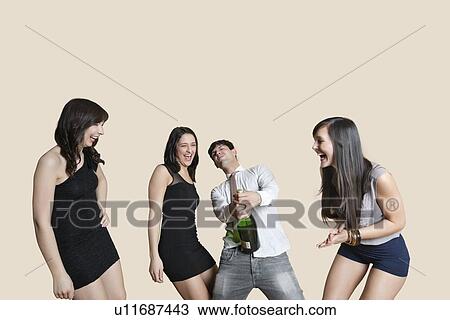 Cheerful young friends with champagne over colored background View Large Photo Image Stock Image - Cheerful young friends with champagne over colored background. Fotosearch