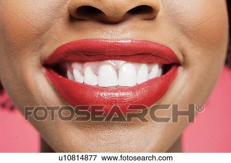 Close-up detail of an African American woman smiling over colored background View Large Photo Image Stock Photo - Close-up detail of an African American woman smiling over colored background. Fotosearch