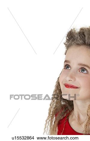 Picture - Close-up of a happy school girl looking up over white background. Fotosearch
