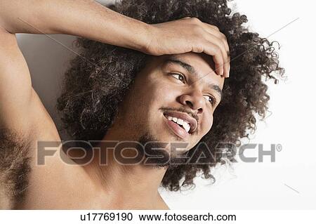 Close-up of a happy young man with hand on head over white background View Large Photo Image Stock Image - Close-up of a happy young man with hand on head over white background. Fotosearch