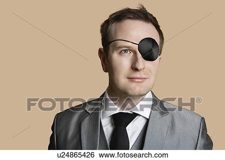 Close-up of a young businessman with eye patch looking away over colored background View Large Photo Image Stock Photograph - Close-up of a young businessman with eye patch looking away over colored background. Fotosearch