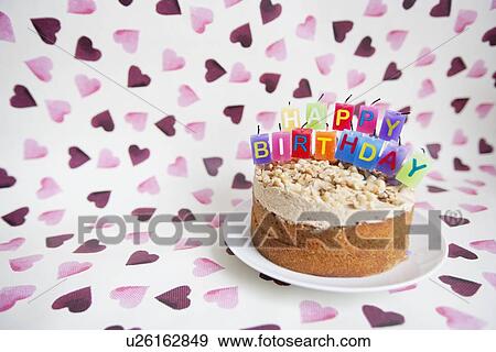 Stock Photo - Close-up of birthday candles on cake over heart shaped background. Fotosearch