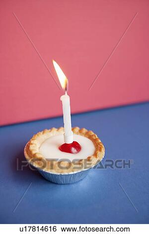 Close-up of candle burning on cupcake over colored background View Large Photo Image Stock Photograph - Close-up of candle burning on cupcake over colored background. Fotosearch