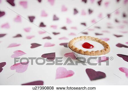 Stock Photo - Close-up of cupcake over heart shaped background. Fotosearch