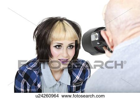 Picture - Close-up of fashion photographer with model posing in studio. Fotosearch