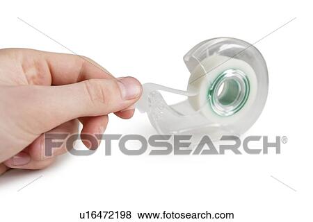 Stock Photo - Close-up of man removing adhesive tape from dispenser. Fotosearch