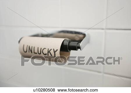 Stock Photo - Close-up of text written on empty toilet paper roll in bathroom. Fotosearch