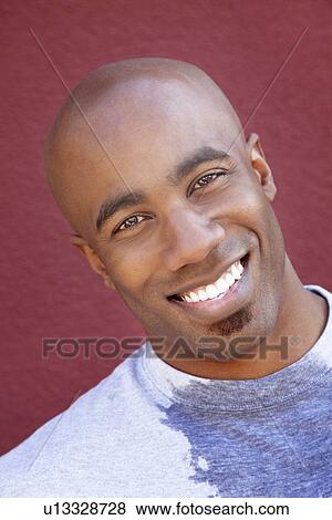 Stock Photo - Close-up portrait of an African American man over colored background. Fotosearch