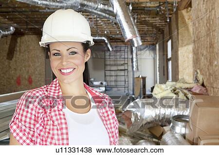 Close-up portrait of smiling young woman contractor at construction site View Large Photo Image Stock Photo - Close-up portrait of smiling young woman contractor at construction site. Fotosearch
