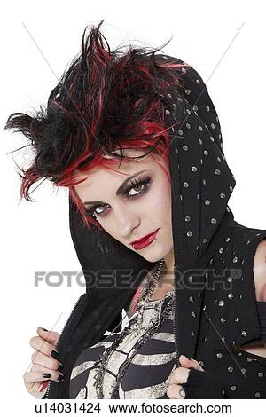 Picture - Close-up portrait of young punk woman wearing hood over white background. Fotosearch