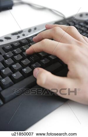 Stock Photo - Cropped image of a hand on computer keyboard. Fotosearch