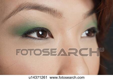 Stock Image - Cropped image of Asian woman looking away. Fotosearch