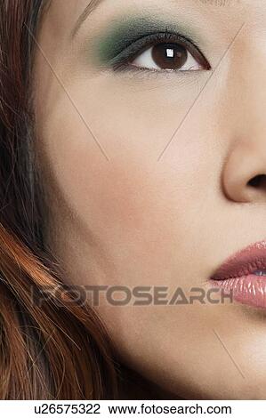 Stock Image - Cropped image of beautiful Chinese woman with makeup looking away. Fotosearch