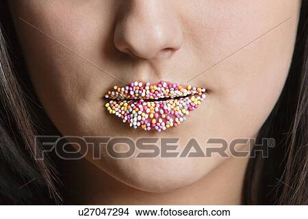 Picture - Cropped image of Caucasian woman with sprinkle candy lips. Fotosearch